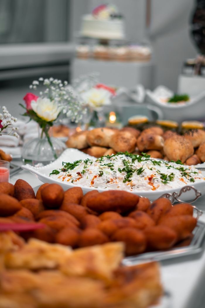 A delectable array of appetizers at a buffet, including meat dishes and garnished salads, elegantly presented.