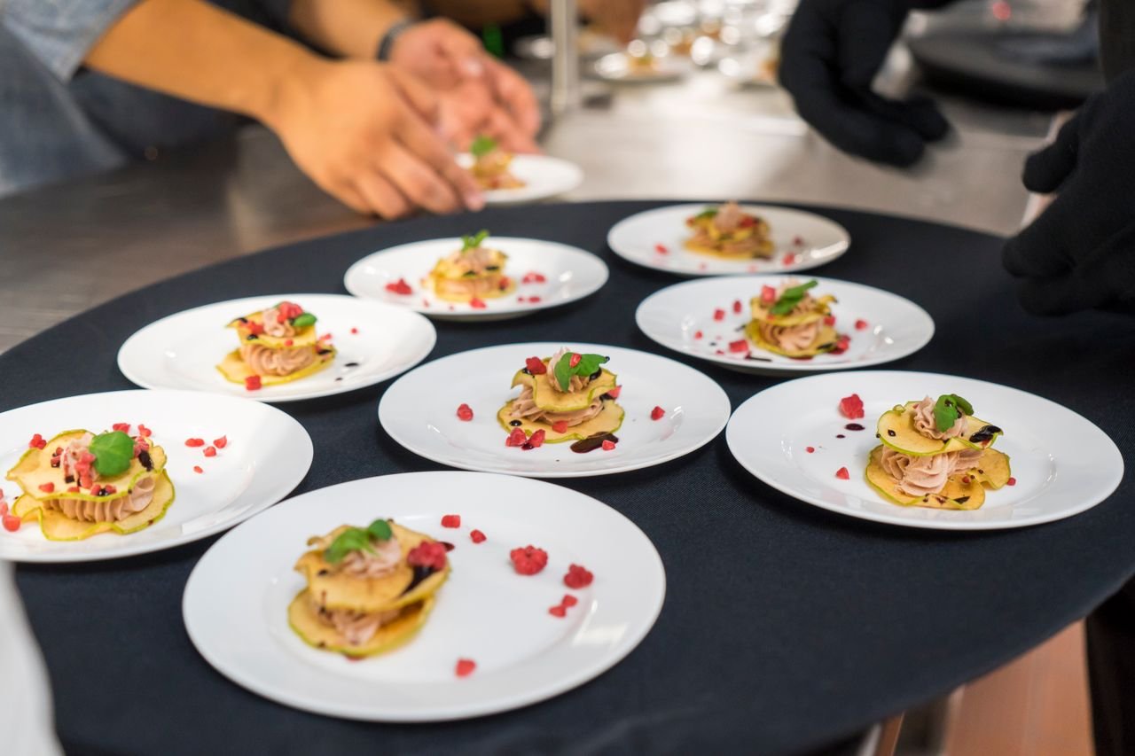 A chef's creative presentation of gourmet appetizers on elegant plates. Shot from above.