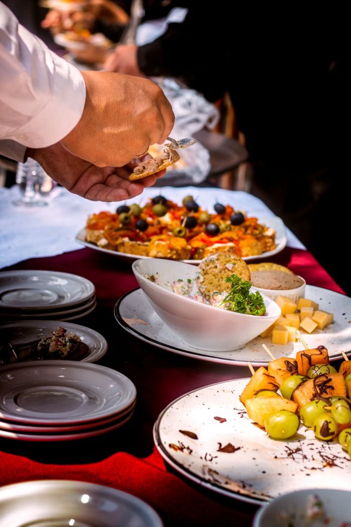 Close-up of a buffet table with diverse appetizers, fruits, and cheese.